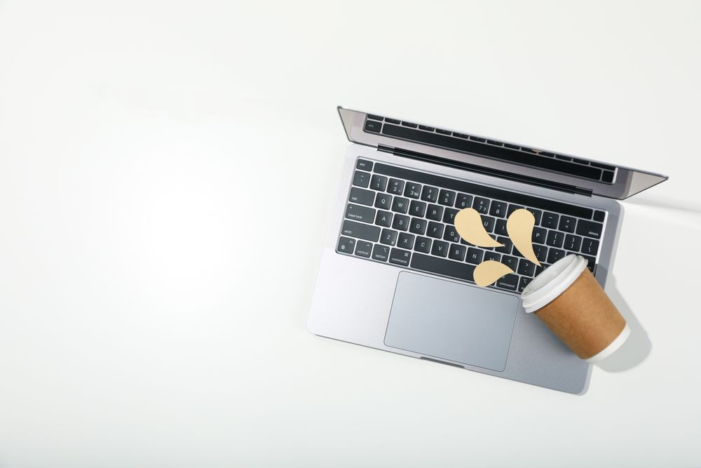 Top view of laptop with mock spilled coffee with copy space