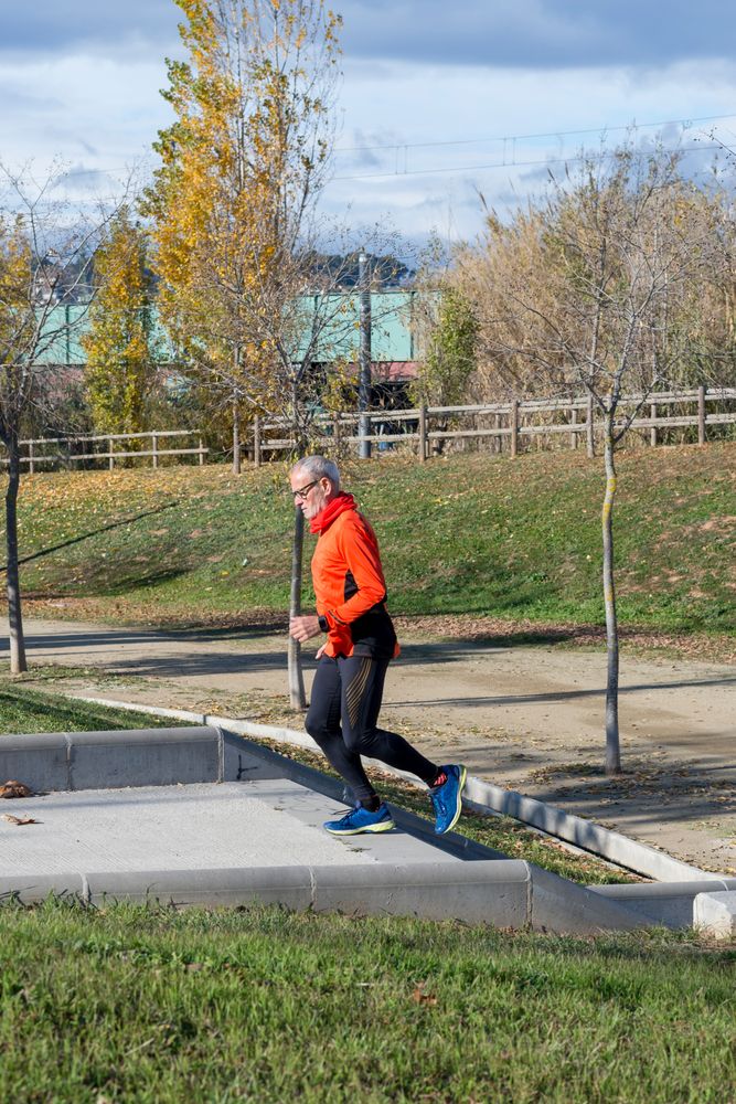 Side view of fit male running up steps outside