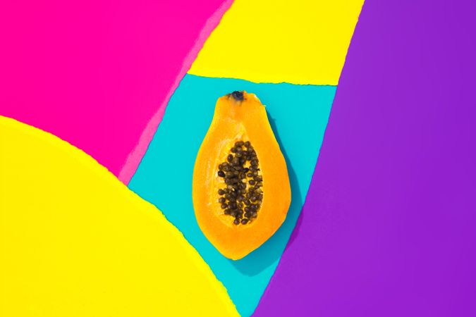 Papaya on pattern of ripped paper in vivid colors