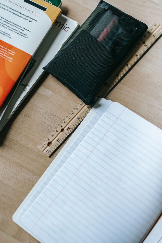 Top view of stationary and books on wooden table