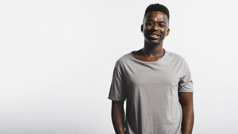 African male in eyeglasses and tshirt isolated on neutral background
