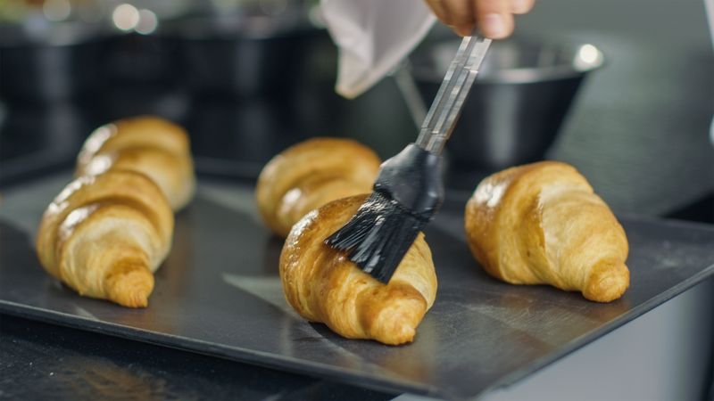 Professional French Baker Butters Croissants.