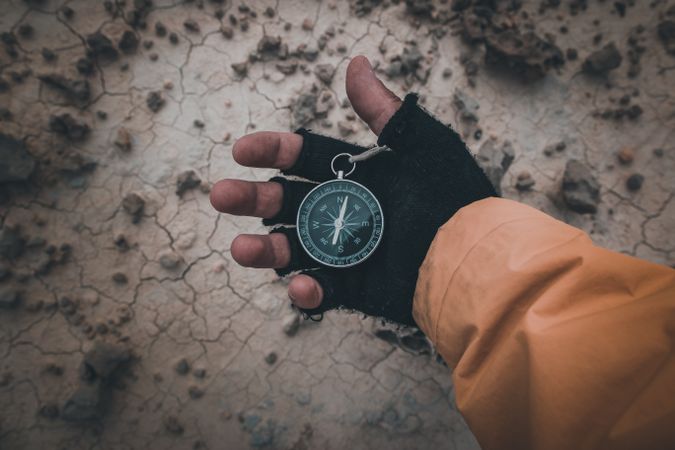 Compass in hand on dry desert area