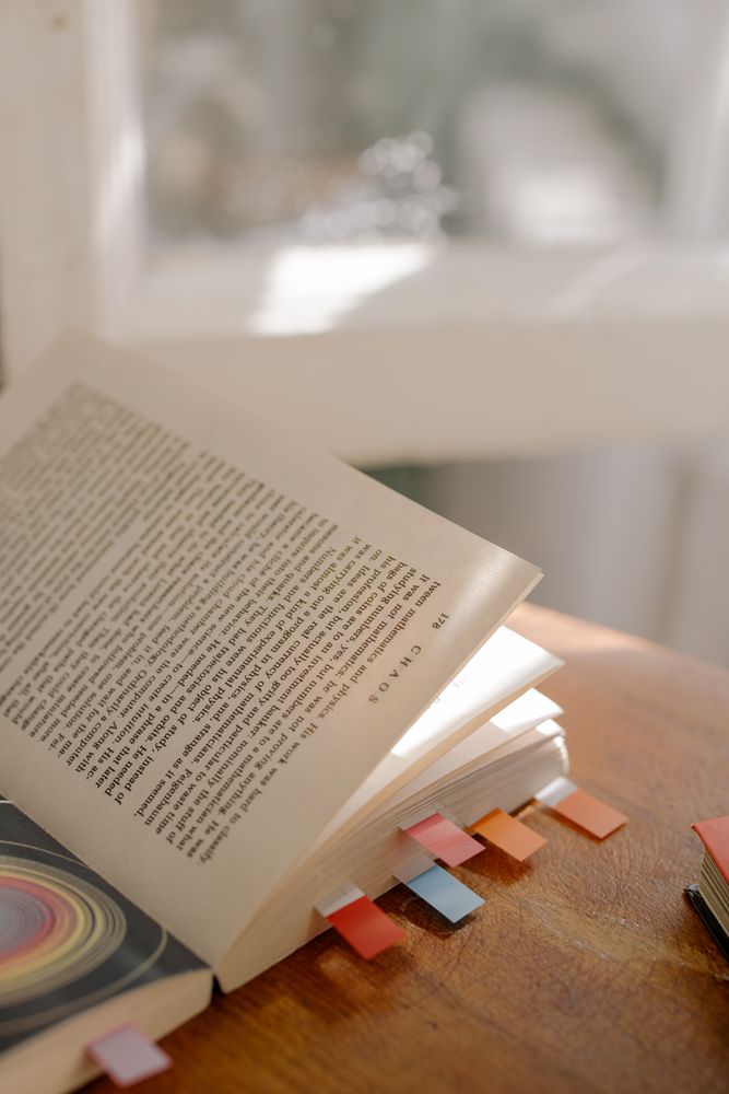 Book with sticky markers on wooden table