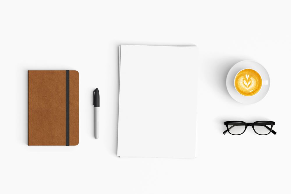 Modern workspace with coffee cup, paper, notebook and tablet copy space