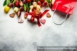 Tulips, shopping bag and checkered heart ornaments with present on grey counter 5qkkvq