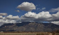 Foothills under a vast blue sky with clouds