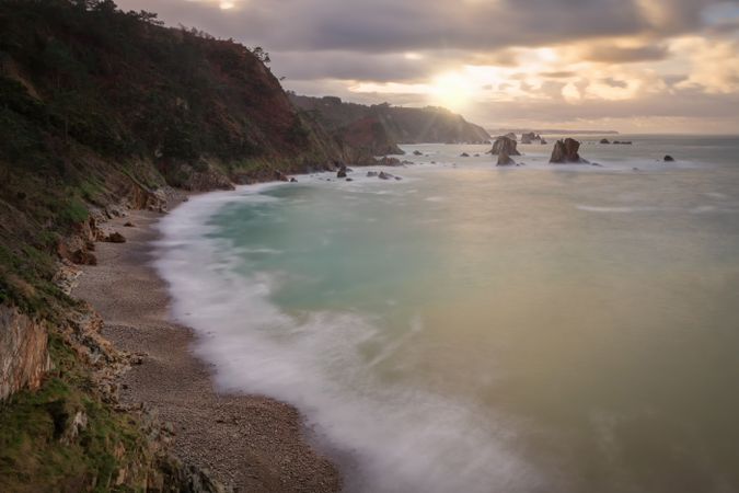 Quiet beach with rocks during sunset
