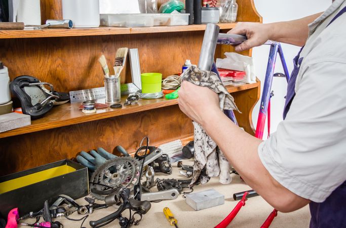 Hands of real bicycle mechanic cleaning frame bike