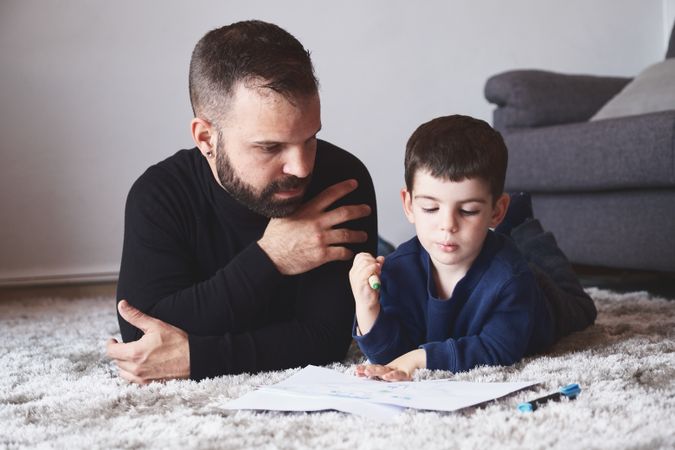 Father and son drawing on floor
