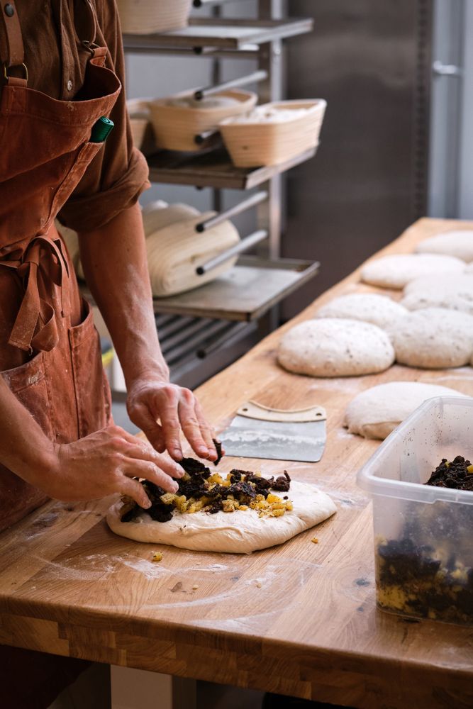 Detail of a baker's hands introducing ingredients into the bread
