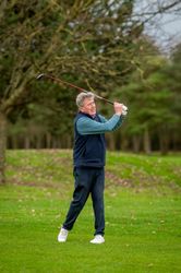 Man finishing swing on golf course