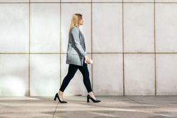 Side view of a businesswoman in a suit and heels on her way to the office
