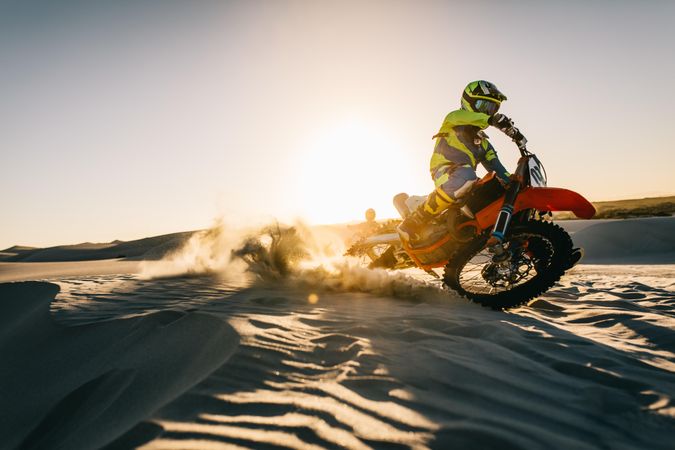 Motocross driver in action driving the motorbike in desert