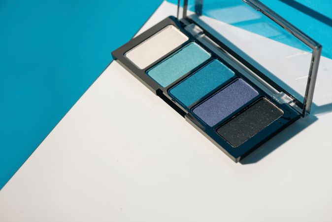 soft blue eyeshadow palette on geometric background.