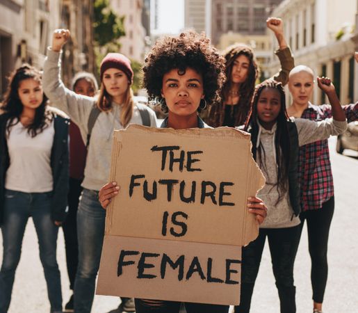 Protesters hold up signs of the future is female
