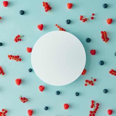 Berry fruit pattern on pastel blue background with paper circle