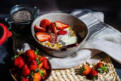 Bowl of oatmeal, chia seeds and strawberry with copy space
