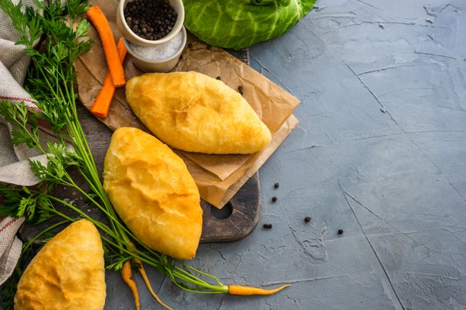 Savory pies with cabbage and carrot on kitchen counter with copy space