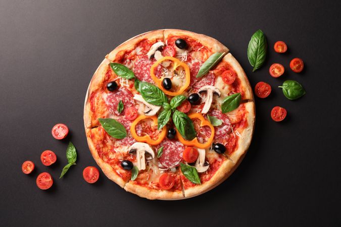 Delicious pizza and tomatoes on dark background, copy space
