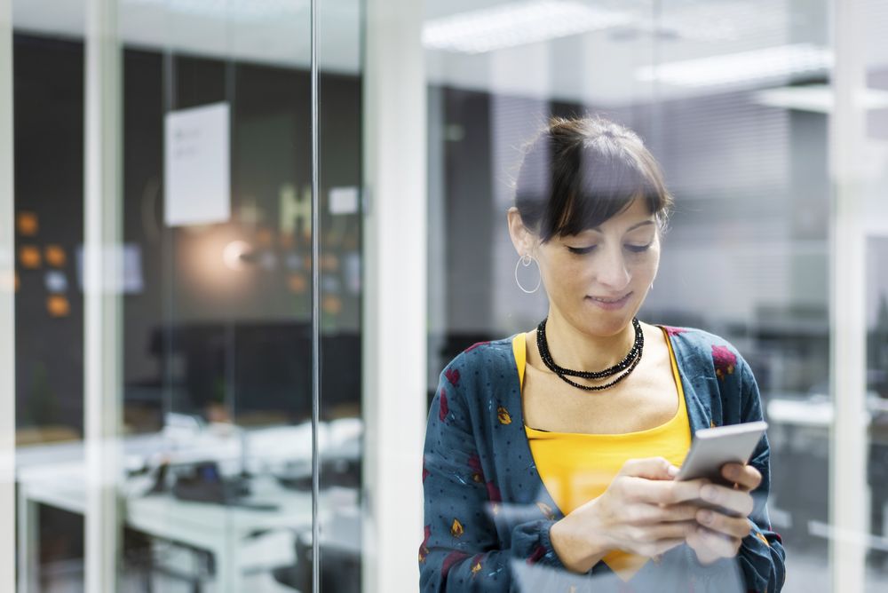 Woman browsing smartphone in office