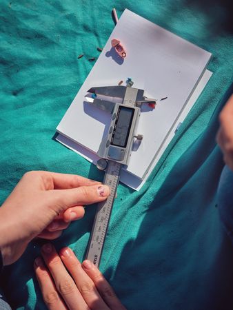 Crop preteen girl adjusting digital caliper while measuring plas