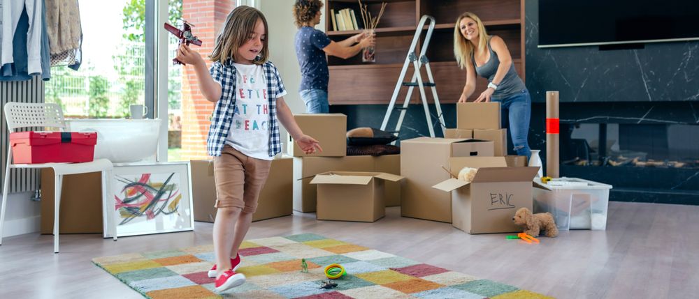 Boy playing with toy airplane while parents unpack
