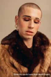 Close-up of man wearing makeup, earring and fur coat 0Pzor4