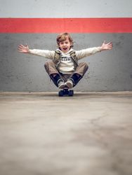 Funny child sitting on skateboard