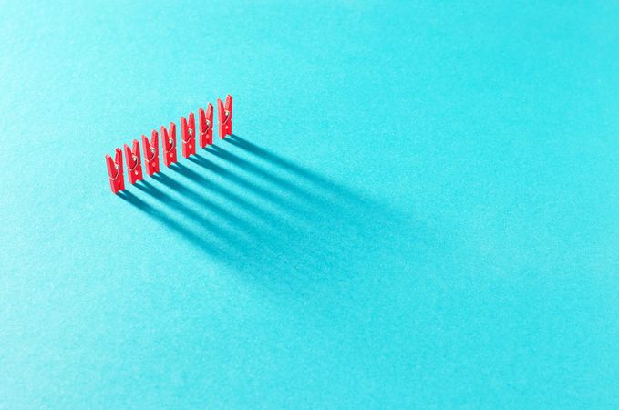 Red clothes pins on aqua background