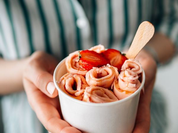 Hand holding rolled ice cream in cone cup