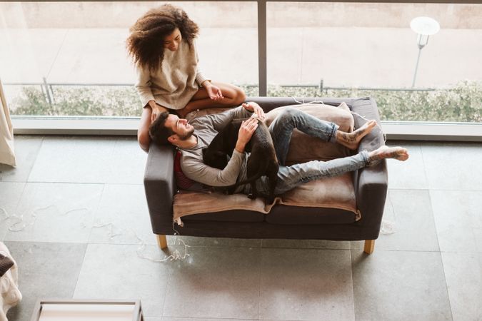 Multiethnic couple with dog on couch