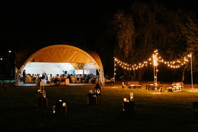 Exterior view of people celebrating wedding in tent