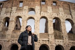 Cheerful Asian traveler outside famous landmark