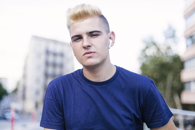 Portrait of young blond man on the street while looking at the camera