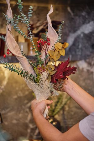 Anonymous woman showing floral composition in flower shop