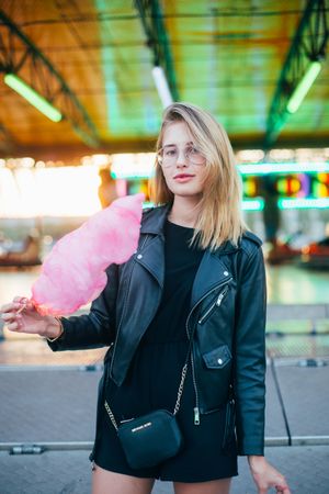 Trendy woman standing in underpass posing with cotton candy