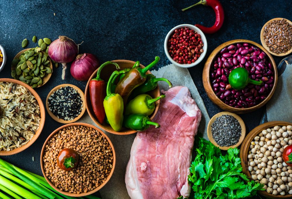 Dark kitchen counter with grains and aromatics for pork meal