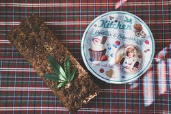 Loaf of grainy bread infused with cannabis and a cookie tin