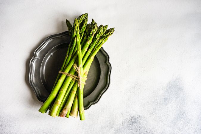 Bunch of asparagus on dark plate