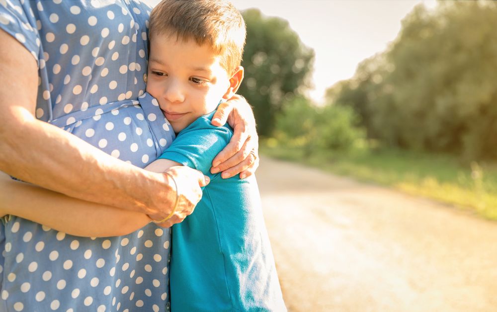 Grandson hugging his grandmother outdoors