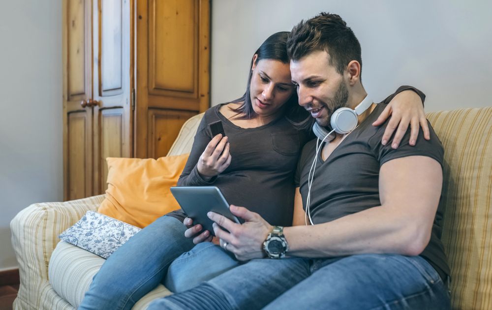 Pregnant with her partner looking at the tablet