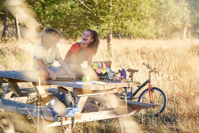 Children having fun and using gadgets in recreation area in natu