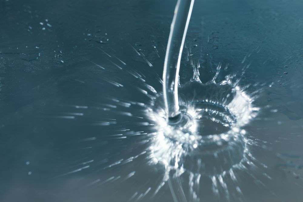 Pouring water on metallic blue surface