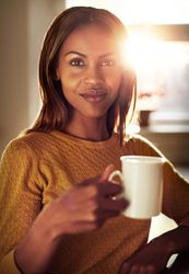Portrait of woman with mug in sunny room