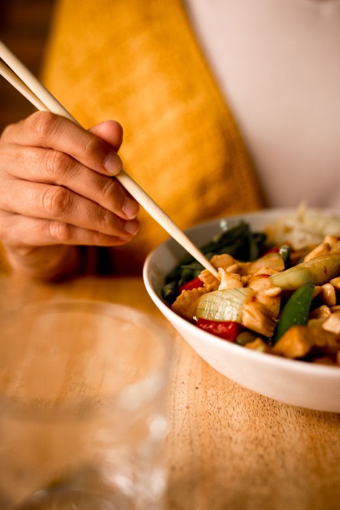 Female eating bowl of cooked appetizing diet dish
