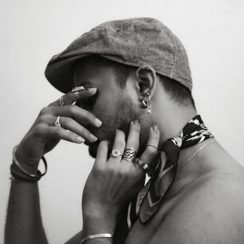 Grayscale photo of topless man wearing tie and hat