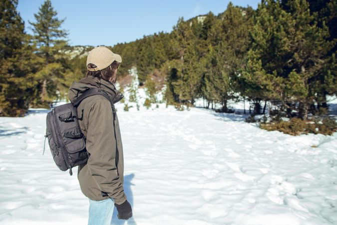 Man between winter forest in sunny day