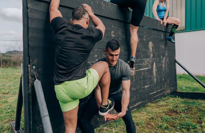 Participants in obstacle course climbing wall
