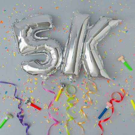 Silver balloons reading 5k with confetti